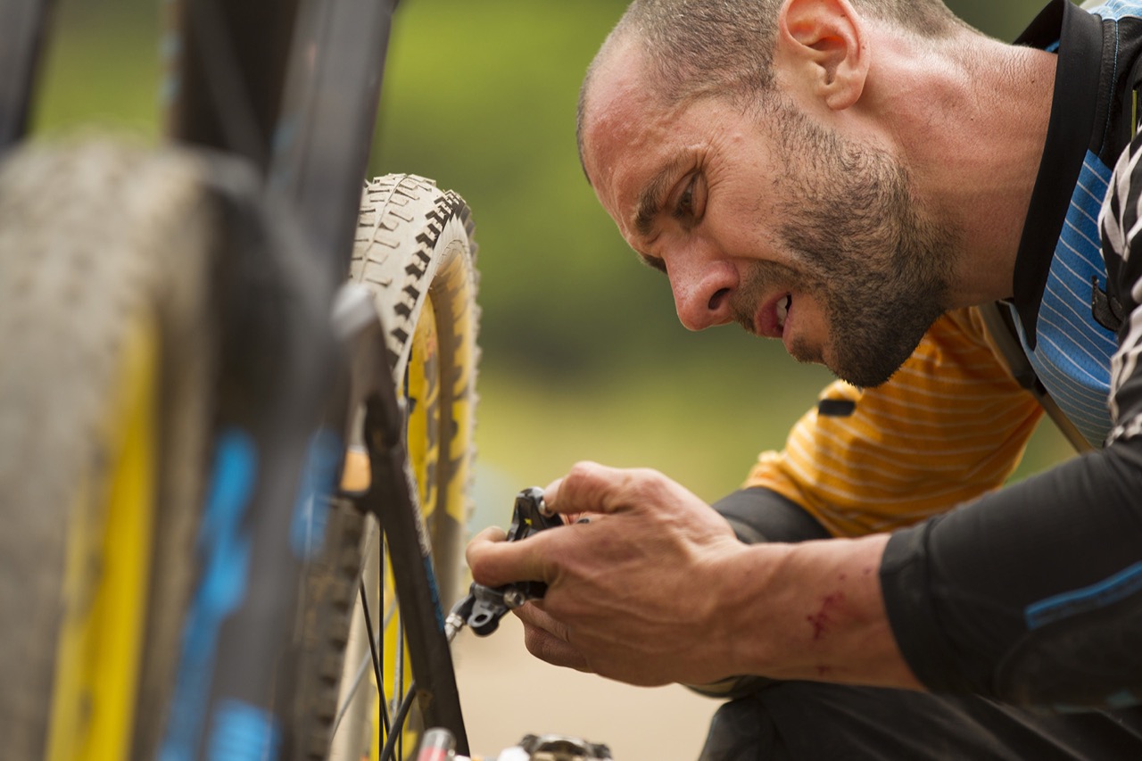 14 February 2015 - Fabien Barel inspects his brakes after he got some course tape wrapped around his wheel during Day 4 of the 2015 Andes Pacifico Enduro stage race near Matanzas, Chile. Photo by Gary Perkin