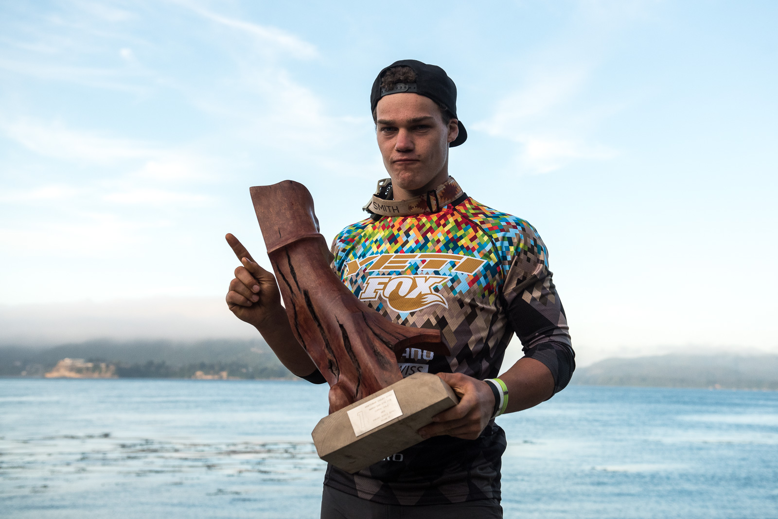 Richi Rude posa con su trofeo original de La Región de los Rios hecho por un artesano de maderas que ya estan muertas y son rescatadas para transformarlas en esculturas.